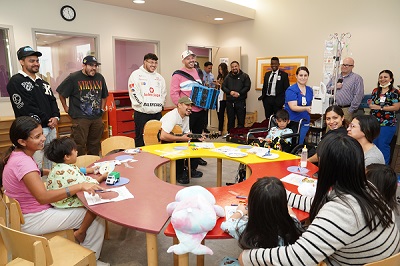 Members of Grupo Frontera performing in front of children at the hospital