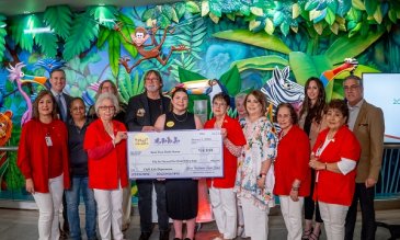 Spirit Halloween and STHS Children's staff holding donation check