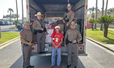 Isaac Garza and local police posing with toy drive u-haul