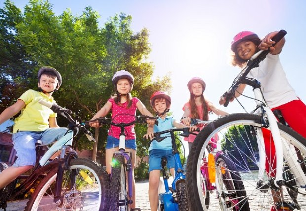 A group of children riding bikes on a summer day.