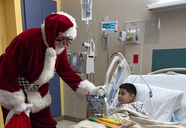 Santa delivering a present at STHS Children's