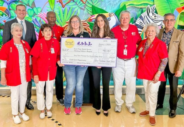 Hospital administrators holding the large check
