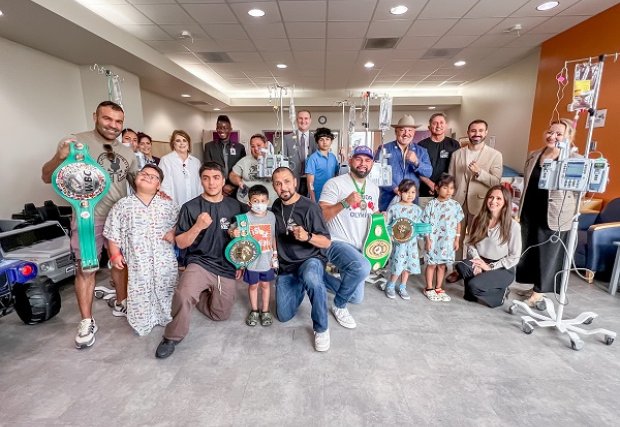 RGV Boxers posing with STHS Children's patients holding their championship belts.