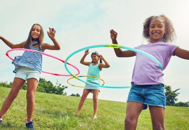 young girls hula hooping in a park