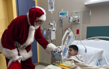 Papá Noel entregando un regalo en STHS Children's