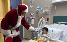 Santa delivering a present at STHS Children's