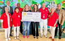 Hospital administrators holding the large check