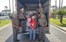 Isaac Garza and local police posing with toy drive u-haul